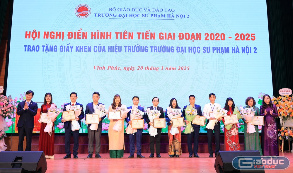 Phó Giáo sư, Tiến sĩ Nguyễn Quang Huy - Hiệu trưởng Trường Đại học Sư phạm Hà Nội 2 và Tiến sĩ Nguyễn Thị Hạnh - Phó Vụ trưởng Vụ Tổ chức cán bộ (Bộ Giáo dục và Đào tạo) trao tặng Giấy khen của Hiệu trưởng nhà trường cho 11 tập thể điển hình tiên tiến. GDVN_ảnh tậpt hể.jpg
