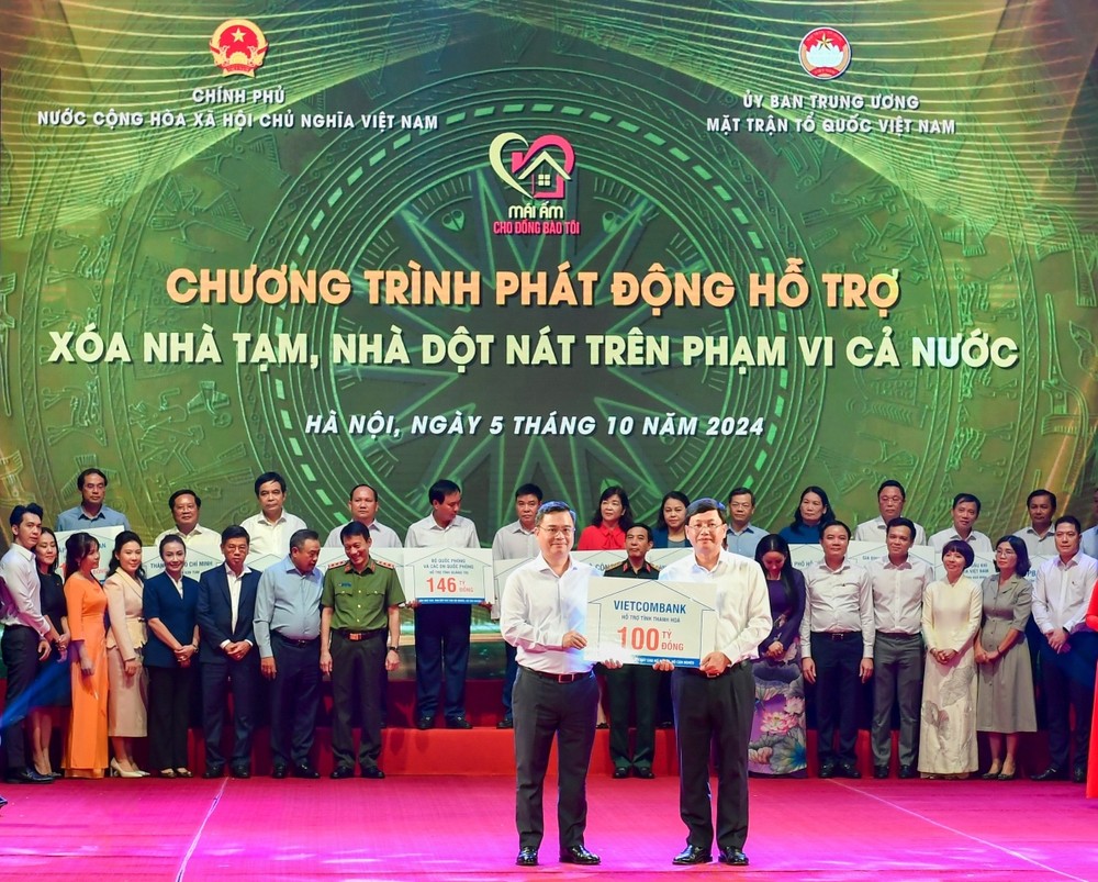 Ông Nguyễn Thanh Tùng (bên trái) - Bí thư Đảng uỷ, Chủ tịch Hội đồng quản trị Vietcombank trao tượng trưng kinh phí 100 tỷ đồng hỗ trợ xóa nhà tạm, nhà dột nát ủng hộ cho địa phương. Ảnh: Duy Thanh 20250124_QHCC_Phongvan_ChutichHDQTVietcombank_02.jpg