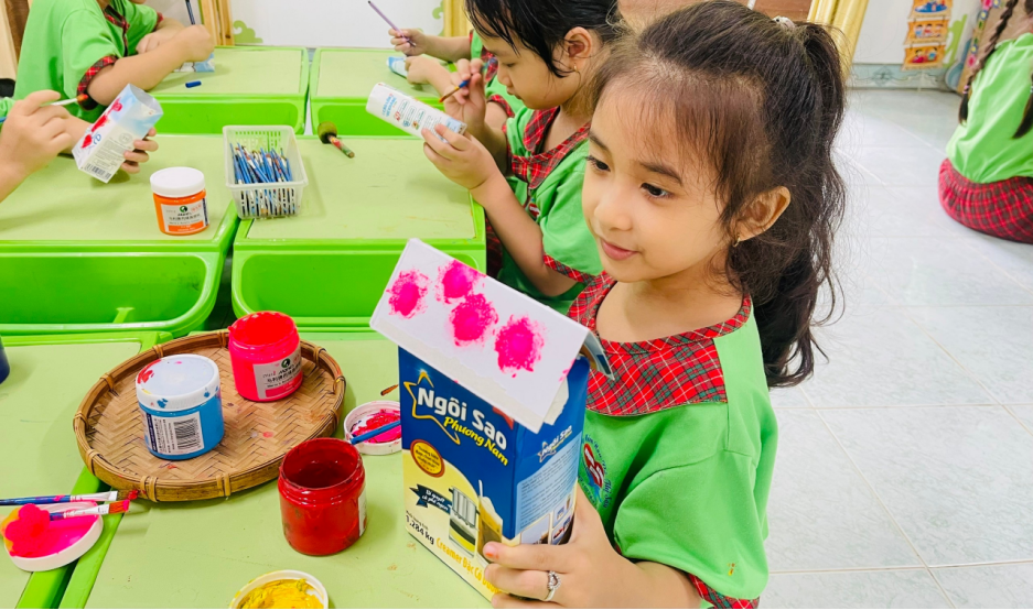 Các em học sinh được tự tay tái chế những vỏ hộp sữa thành những món đồ chơi sáng tạo. (Ảnh: NVCC) unnamed (94).png
