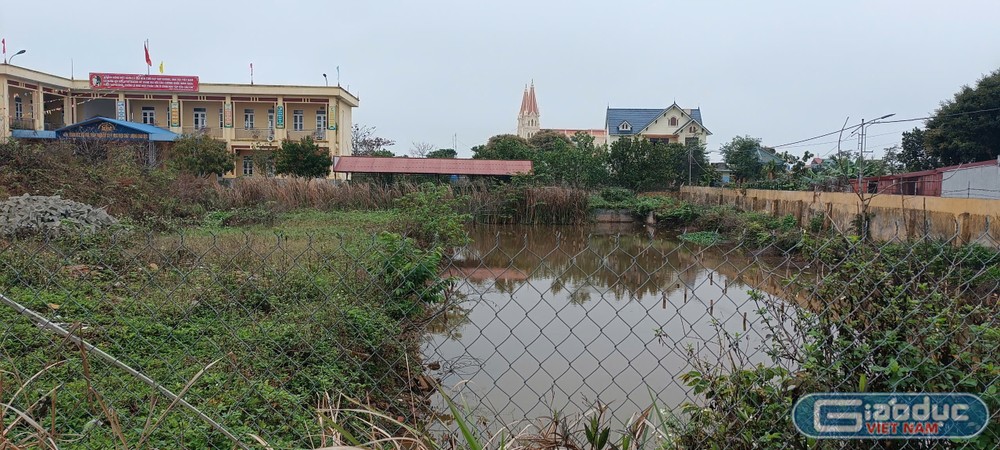 Phía bên tay phải cổng trường có hồ nước chạy dài là nơi xây dựng móng nền nhà bị bỏ dở. (Ảnh: NVCC) gdvn_truong-tieu-hoc-hong-thuan-nam-dinh (4).jpg