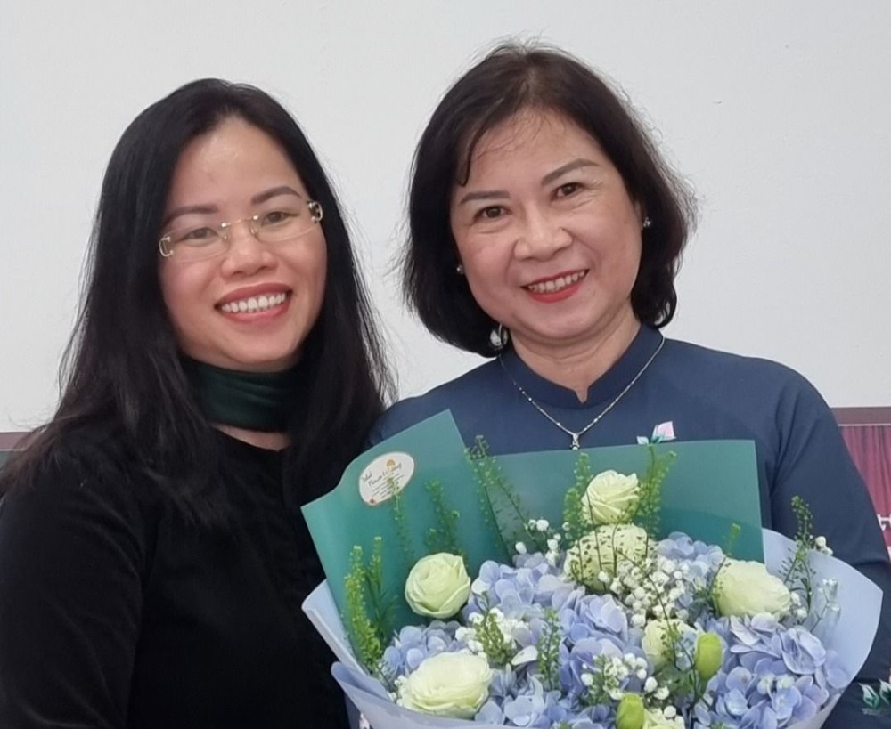 Phó Giáo sư Nguyễn Thị Việt Thanh (bên phải) nhận hoa từ một học trò cũ (Ảnh: NVCC). z5086416061576_d697f96bb3e641b2fbc77b51d9c34a9d.jpg
