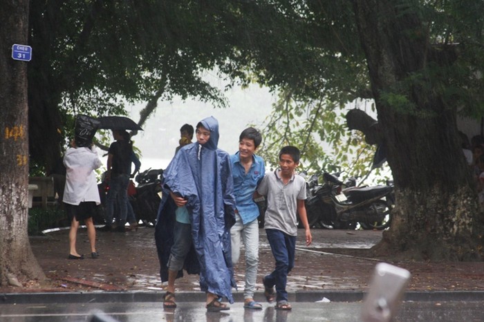 Đang cùng người thân dạo chơi quanh hồ Hoàn Kiếm dịp tết độc lập, nhiều người phải tìm chỗ trú vì những cơn mưa nhỏ bất thường