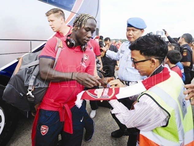 Hậu vệ Bacary Sagna ký tặng nhân viên sân bay ngay sau khi hạ cánh xuống Jakarta, Indonesia. ảnh: Arsenal.com.
