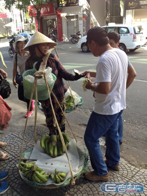 Một nhóm khách du lịch Trung Quốc vừa bẻ chuối vừa ăn rồi ném vỏ chuối vào giỏ của người bán chuối hàng rong tại Đà Nẵng được nhạc sĩ Nguyễn Duy Khoái ghi lại. Ảnh: Nhạc sĩ Nguyễn Duy Khoái.