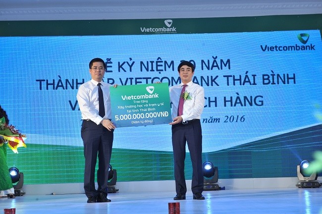 Ông Nghiêm Xuân Thành - Ủy viên Ban Chấp hành Đảng bộ Khối Doanh nghiệp Trung ương, Bí thư Đảng ủy, Chủ tịch Hội đồng quản trị Vietcombank (bên phải) trao số tiền 5 tỷ đồng tài trợ xây dựng 1 trường học, 1 trạm y tế cho tỉnh Thái Bình.