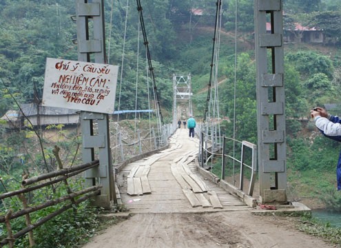 Vết nứt kéo dài từ đỉnh núi xuống bờ sông, bẻ cong chiếc cầu treo khiến người dân hoang mang, lo lắng. Ảnh: N.K