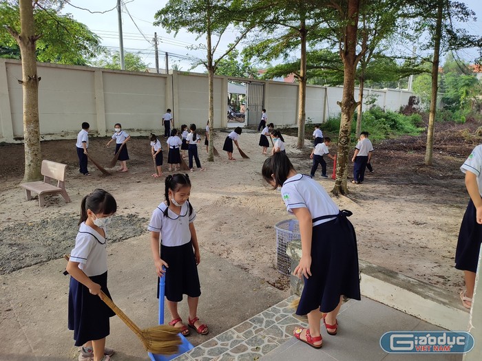 Học sinh lớp 2 đang quét dọn vệ sinh mỗi buổi đến trường. Ảnh: Phan Tuyết