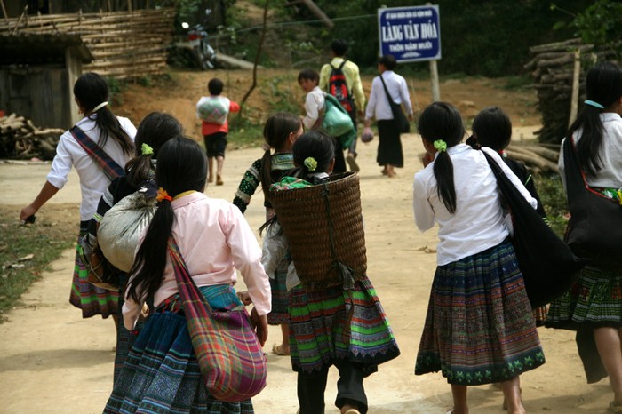 Dưới trời nắng nôi, các em vừa đi vừa trò chuyện rất vui vẻ. Các em trong 1 xã thường tập trung lại với nhau cùng tới trường.