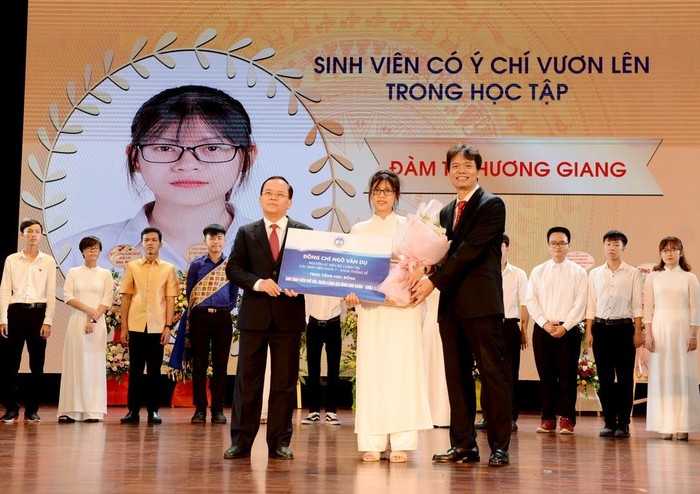 Phó giáo sư Phạm Hồng Chương – Hiệu trưởng nhà trường và ông Ngô Văn Dụ - nguyên Ủy viên Bộ Chính trị, nguyên Bí thư Trung ương Đảng, nguyên Chủ nhiệm Ủy ban kiểm tra Trung ương trao học bổng cho tân sinh viên Đàm Thị Hương Giang có hoàn cảnh khó khăn với học bổng trị giá 80 triệu đồng.(Ảnh: NEU)