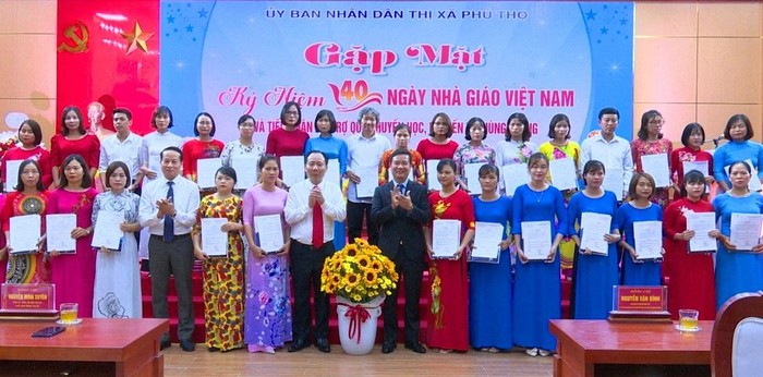 Nhà báo Nguyễn Tiến Bình (áo vest) - Phó Chủ tịch Hiệp hội Các trường đại học, cao đẳng Việt Nam kiêm Tổng Biên tập Tạp chí điện tử Giáo dục Việt Nam và lãnh đạo thị xã Phú Thọ trao thưởng cho 40 giáo viên có hoàn cảnh khó khăn nhưng đã nỗ lực vươn lên hoàn thành xuất sắc các nhiệm vụ của ngành trong năm học 2021-2022, tổng số tiền 120 triệu đồng.