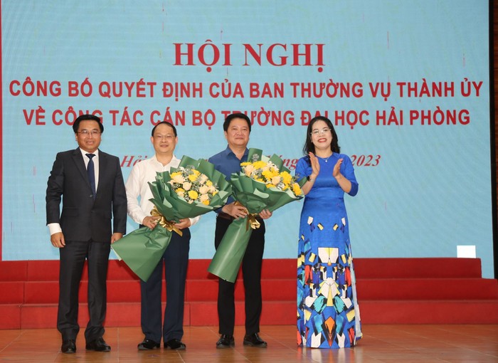Tân lãnh đạo Trường Đại học Hải Phòng tặng hoa ông Nguyễn Văn Kính và ông Nguyễn Hoài Nam (Ảnh: LT)