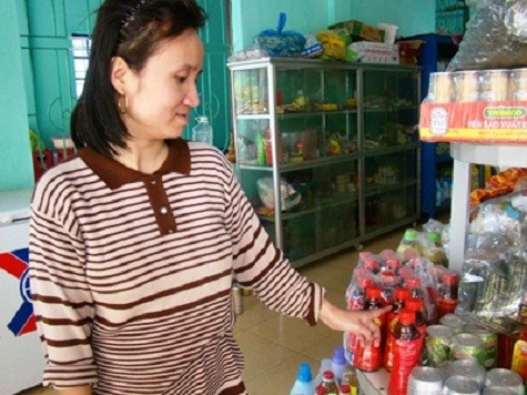 Bà Hà - chủ quầy hàng tạp hóa đóng tại tiểu khu 7, phường Đồng Phú, TP Đồng Hới chỉ những chai nước giải khát Dr.Thanh bị kết tủa (Ảnh: Dân Trí)
