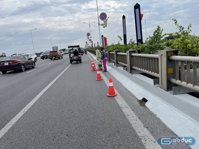 Công nhân đang sơn sửa lại hai bên hành lang của Cầu Vĩnh Tuy 1 để tạo ra sự đồng bộ, mới mẻ trong ngày khánh thành. Ảnh: Trung Dũng