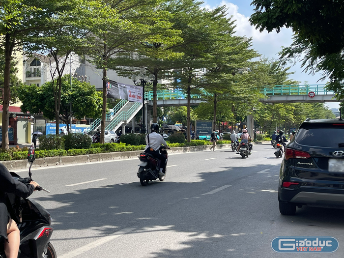 Một sinh viên đi bộ qua đường ngay trước cổng Trường Cao đẳng Cộng đồng Hà Nội. Ngay cạnh cổng trường có cầu vượt đi bộ nhưng có rất ít người đi lại.