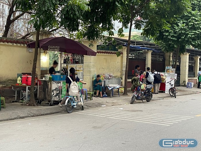 Học sinh dễ dàng mua đồ ăn được bán ở các hàng quán trước cổng trường. Ảnh: Trung Dũng