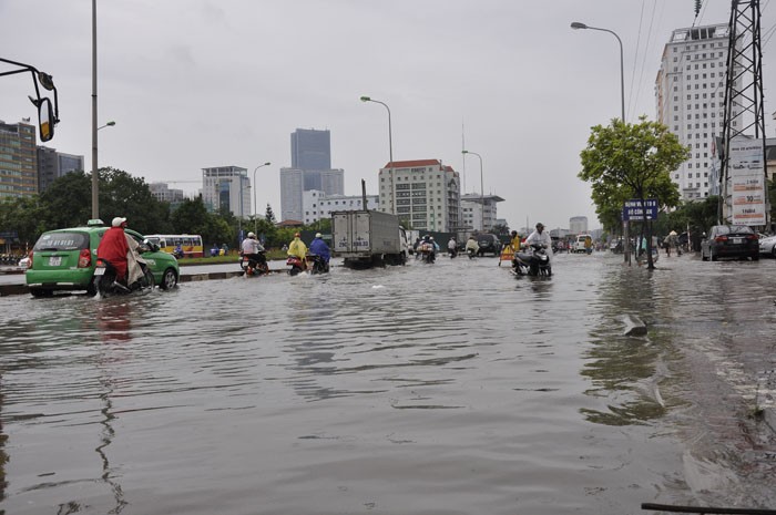 Nước ngập sâu, các phương tiện dạt hết về một bên và lưu thông rất chậm khi qua các điểm ngập úng.