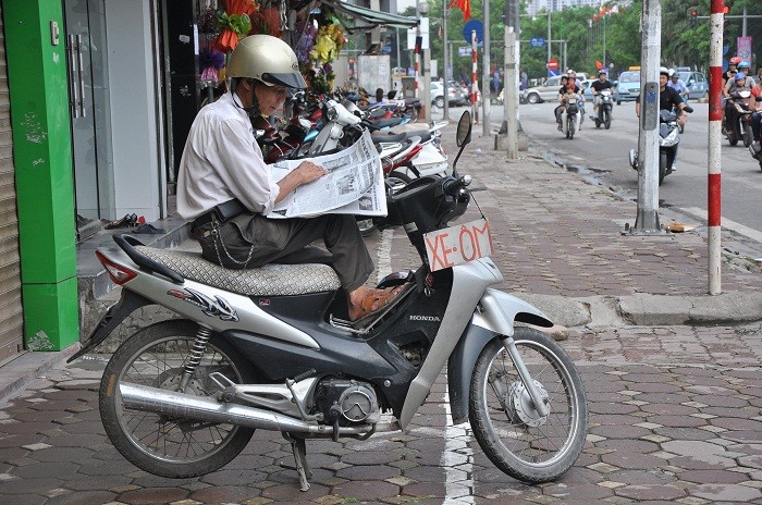 Bác Trung đang tranh thủ đọc báo khi không có khách