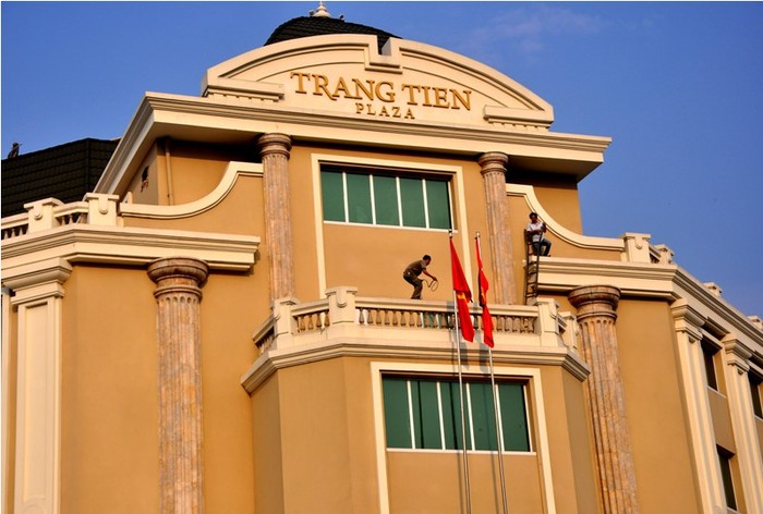 Các nhân viên Tràng Tiền Plaza đang thực hiện việc treo cờ rủ