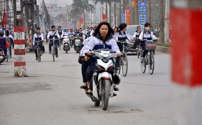 Các học sinh nữ cũng thản nhiên đi xe máy trong tình trạng đầu không đội mũ bảo hiểm, kẹp ba