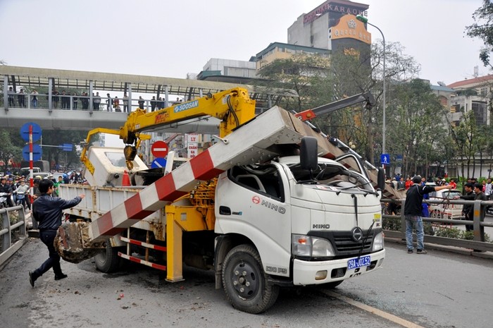 Chiếc xe cẩu biển xanh đã hất tung rào chắn cảnh báo các phương tiện không được phép đi qua cầu vượt nhẹ Thái Hà – Chùa Bộc khiến một người phụ nữ đi xe máy phải cấp cứu trong tình trạng nguy kịch.