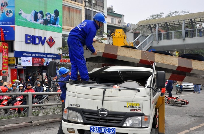 Chiếc thanh ngang đè ngang xuống xe cẩu làm phần kính và đầu xe cẩu bị vỡ và bẹp dúm lại.