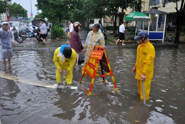 Mở nắp cống thoát nước và dùng máy bơm… tới 10h cùng ngày các điểm ngập úng đã tương đối được khắc phục.