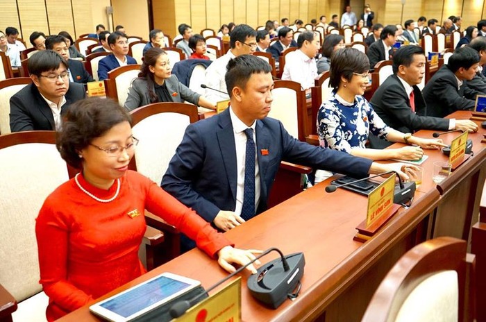 Các đại biểu bấm nút thông qua Nghị quyết phát triển kinh tế - xã hội năm 2018 (ảnh nguồn hanoimoi.com.vn).