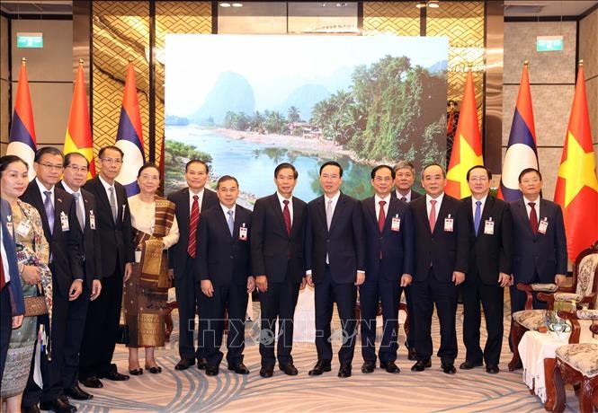 Chủ tịch nước Võ Văn Thưởng và Chủ tịch Ủy ban Trung ương Mặt trận Lào xây dựng đất nước Sinlavong Khoutphaythoune chụp ảnh chung với đại biểu hai nước. Ảnh: Thống Nhất/TTXVN