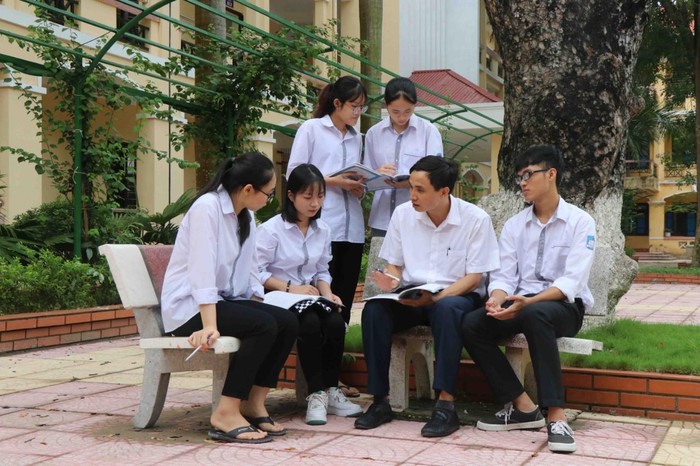 Thầy giáo dạy Hóa học Nguyễn Thùy Dương thường xuyên trao đổi, giải đáp mọi thắc mắc của Ngân (ngồi thứ 2 từ trái vào) và các bạn khi gặp bài khó để tìm ra cách giải hay và ngắn nhất. Ảnh: NVCC.