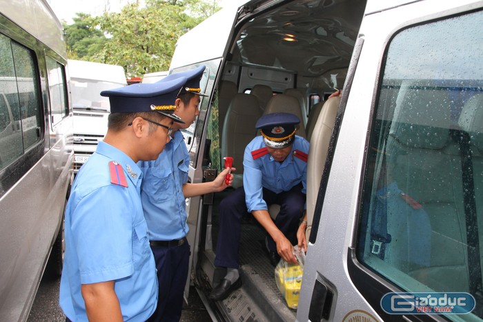 Cán bộ Đội Thanh tra giao thông quận Cầu Giấy kiểm tra chi tiết, kỹ càng các yêu cầu, điều kiện trên xe đưa đón học sinh trường Gateway. Ảnh: Vũ Phương.