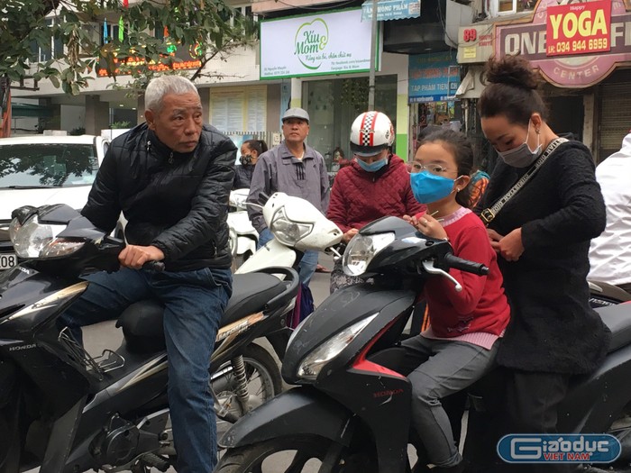 Nhưng cũng có phụ huynh không đeo khẩu trang khi đón con. Ảnh: Vũ Phương.