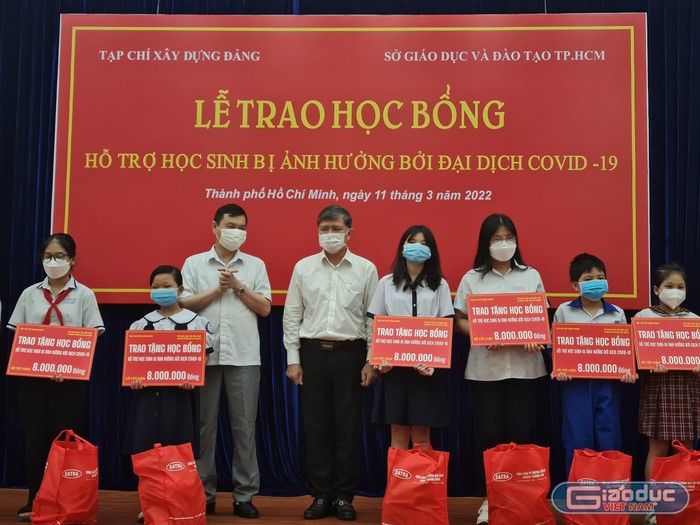 Ông Nguyễn Văn Hiếu (đứng thứ 4, trái sang) trao tặng học bổng cho các em học sinh (ảnh: P.L)