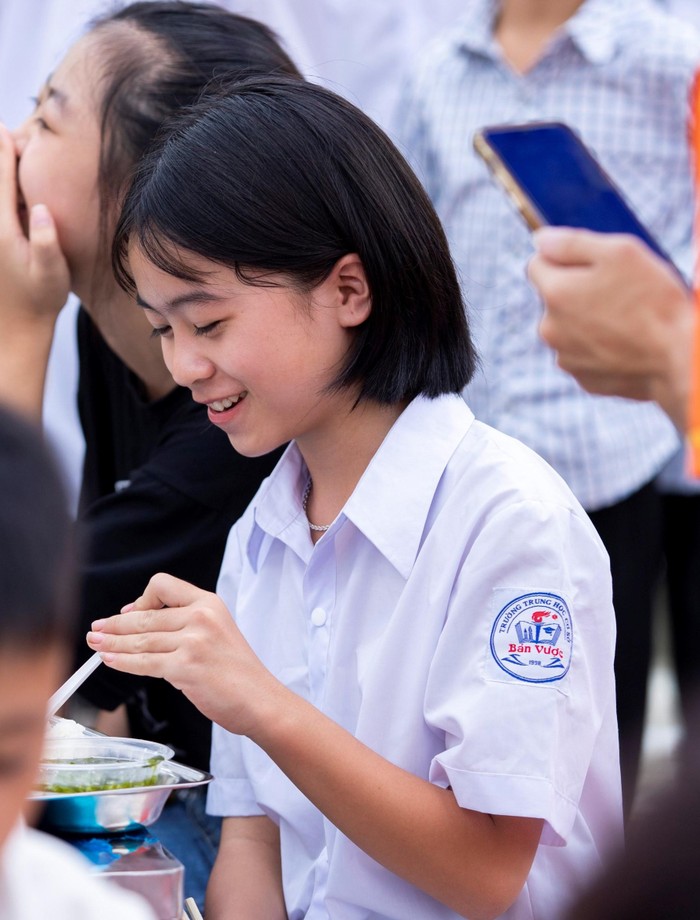 Nụ cười trên môi các em học sinh khi được thưởng thức bữa trưa đầy ấm áp.
