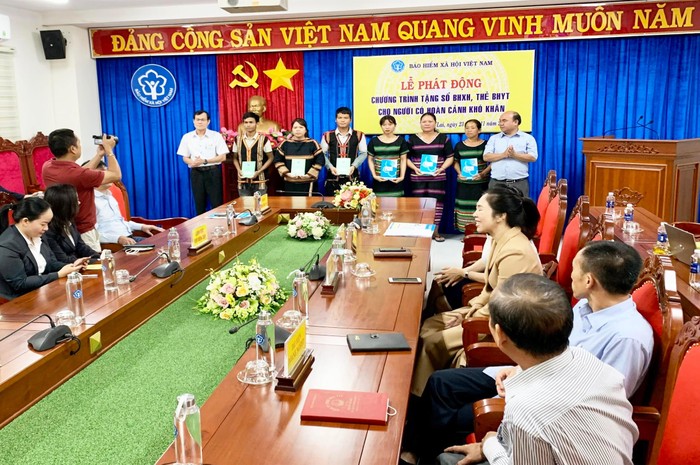 Ông Trần Văn Lực - Giám đốc Bảo hiểm xã hội tỉnh (bên trái) và ông Siu Trung - Phó Chủ tịch Ủy ban Mặt trận Tổ quốc Việt Nam tỉnh (bên phải) trao tặng thẻ bảo hiểm y tế, sổ bảo hiểm xã hội cho người có hoàn cảnh khó khăn.