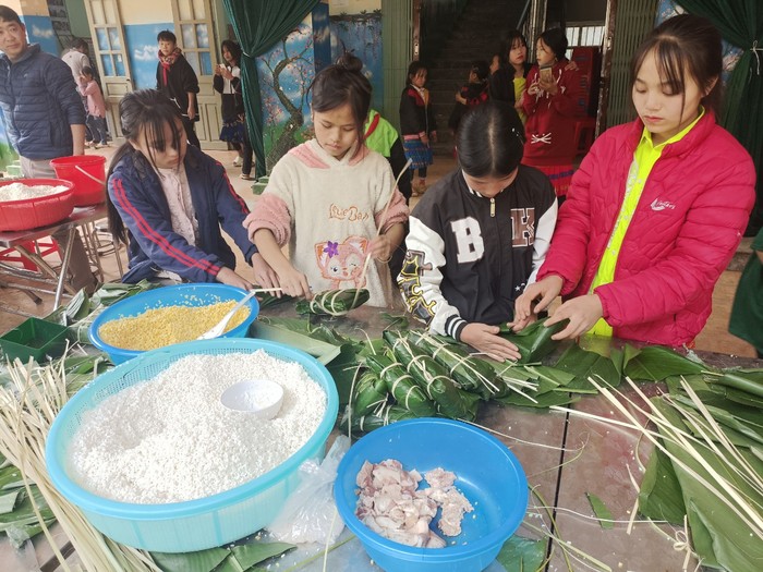 Những học sinh lần đầu được tham gia hoạt động trải nghiệm gói bánh chưng. Ảnh: NTCC