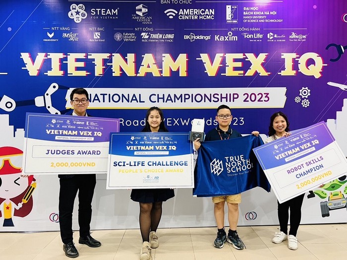 Học sinh Bùi Nguyễn Hà Linh (thứ hai từ trái sang) và Lê Tuấn Minh (thứ ba từ trái sang) nhận giải thưởng sau khi tham dự Giải vô địch VEX IQ Robotics toàn quốc năm 2023.