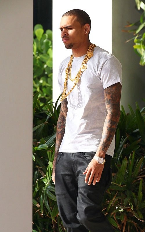 Chris Brown khoe hai chiếc vòng bằng vàng... to tướng trên đường phố Miami, Florida chiều 19/2. Anh đang rời khỏi khách sạn Miami Beach trong bộ áo phông trắng, quần đen và cố tránh phóng viên. Hôm 20 - ngày sinh nhật của bạn gái cũ Rihanna, Chris Brown đăng tải lên Twitter: "Chúc mừng sinh nhật Robyn". (Robyn là tên thật của Rihanna)
