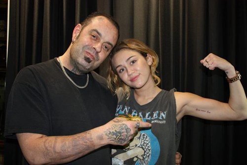 Miley Cyrus tự hào khoe dòng chữ mới được xăm lên bắp tay trái của mình ở cửa hàng xăm, California. Miley xăm dòng chữ khá ý nghĩa lên tay: "Love never dies" ("Tình yêu là bất tử").