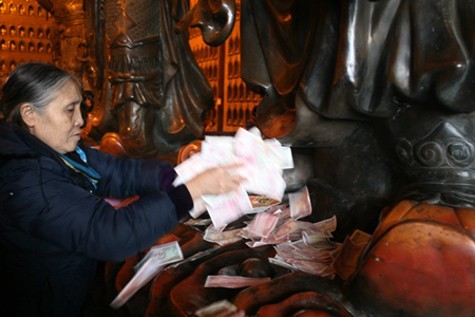 Trong chùa cảnh rải, vứt, chà sát tiền vào chân, vào tay tượng phật của người đi lễ chùa khiến nhiều người không khỏi ngao ngán (Ảnh: Internet).