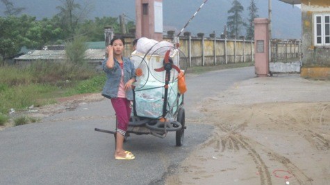 Một người dân tại Nghệ An đang đưa vật dụng trong nhà lên nơi tránh bão