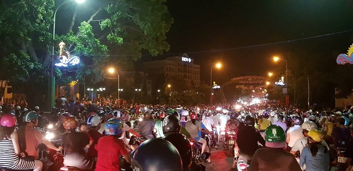 Nhiều người hiếu kỳ xem các thanh niên quá khích ném đá vào cổng trụ sở Uỷ ban nhân dân tỉnh Bình Thuận làm giao thông tắc nghẽn. Ảnh: Plo.vn