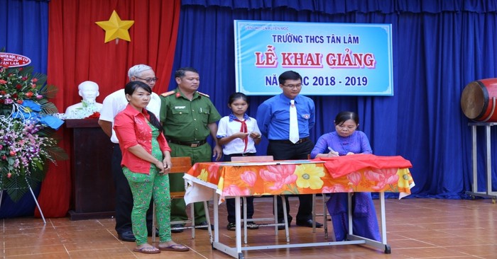 Cô Đặng Thị Nga, người ngồi, ký kết tài trợ học bổng toàn phần cho học sinh với nhà tài trợ