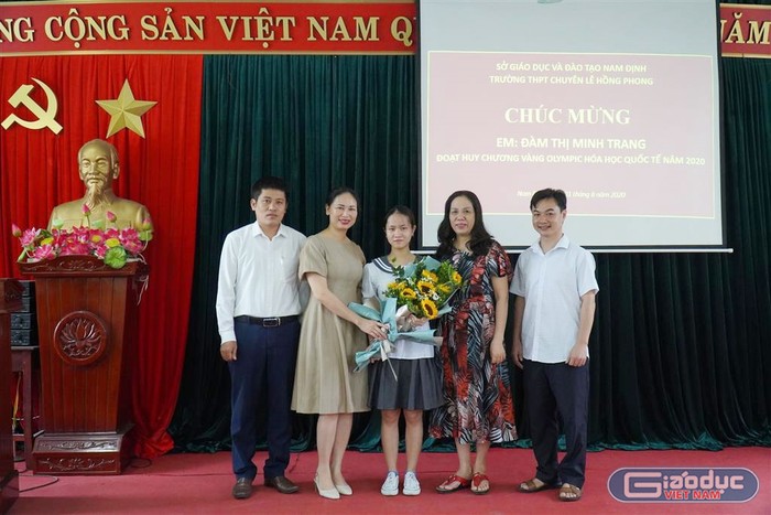 Em Đàm Thị Minh Trang chụp ảnh lưu niệm với Ban giám hiệu Trường Trung học phổ thông Chuyên Lê Hồng Phong. (Ảnh: Trường Trung học phổ thông Chuyên Lê Hồng Phong cung cấp)