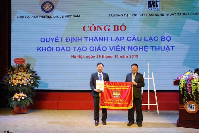 Phó giáo sư, Tiến sĩ Trần Xuân Nhĩ – Phó Chủ tịch Hiệp hội Các trường đại học, cao đẳng Việt Nam trao quyết định thành lập và cờ cho đại diện Câu lạc bộ khối đào tạo giáo viên nghệ thuật, Phó giáo sư, Tiến sĩ Đào Đăng Phượng.