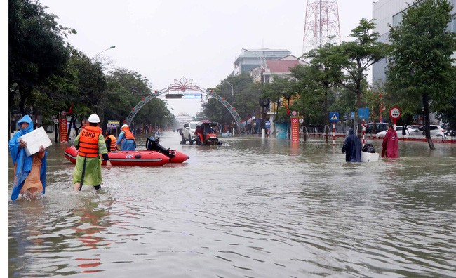 Lực lượng Cứu nạn cứu hộ giúp người dân Hà Tĩnh di chuyển ra khỏi vùng bị ngập (Ảnh: TTXVN)