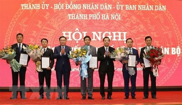 Bí thư Thành ủy Vương Đình Huệ và Chủ tịch Ủy ban nhân dân thành phố - ông Chu Ngọc Anh trao quyết định và tặng hoa chúc mừng 5 tân Phó Chủ tịch Ủy ban nhân dân Thành phố Hà Nội. (Ảnh: Văn Điệp/TTXVN).