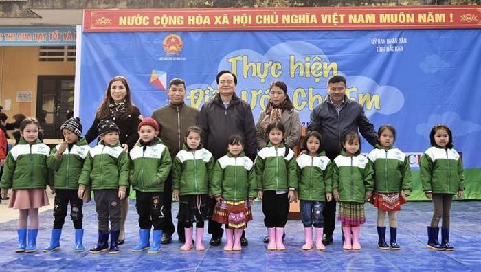 Học sinh Trường Phổ thông dân tộc bán trú Tiểu học và Trung học cơ sở Nhạn Môn, huyện Pác Nặm nhận áo ấm và ủng từ Bộ trưởng Phùng Xuân Nhạ (Ảnh: Bộ giáo dục và Đào tạo)