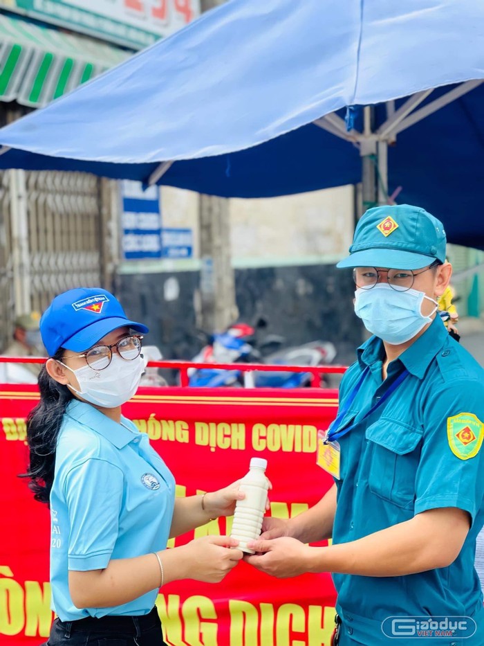 Sinh viên Trương Ngọc Ánh tặng nước mát lực lượng trực chốt kiểm soát phòng chống COVID-19. Ảnh: Nhân vật cung cấp