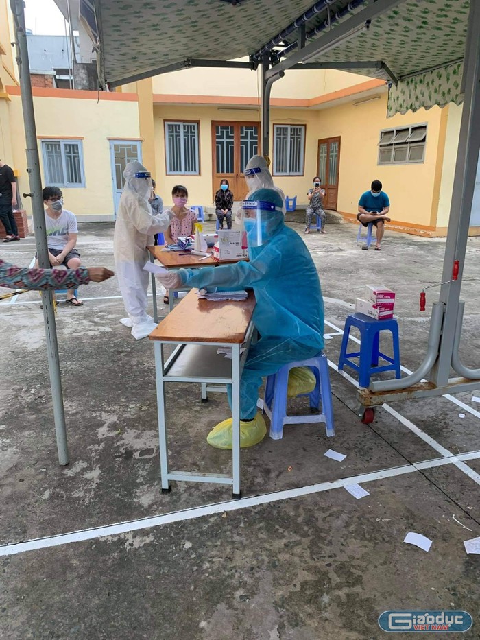 Thầy Nguyễn Tiến Quang (mặc bảo hộ xanh) tham gia tổ test nhanh tại khu phong tỏa phường Tam Hiệp, thành phố Biên Hòa, tỉnh Đồng Nai. Ảnh: Nhân vật cung cấp