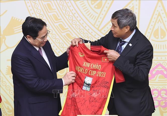 Huấn luyện viên Mai Đức Chung đại diện Đội bóng đá nữ Việt Nam tặng quà lưu niệm cho Thủ tướng Phạm Minh Chính. Ảnh: Dương Giang/TTXVN